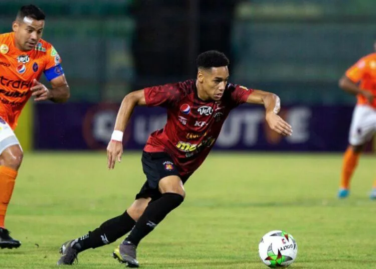 Jugadores del Caracas y de Academia Puerto Cabello se enfrentan en la cancha.